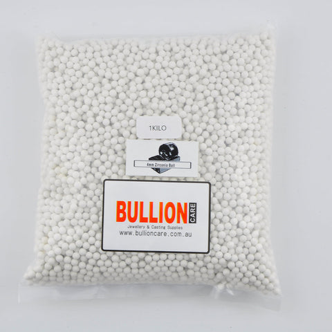 Plastic bag of 4mm white zirconia tumbling media with a '1 Kilo' label and 'BULLIONCARE' branding.