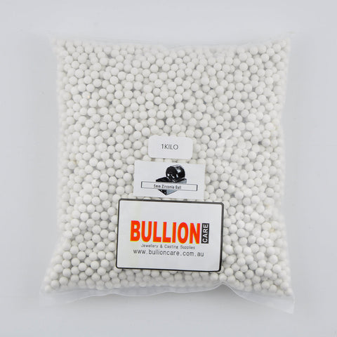 Image of 5mm zirconia tumbling media, featuring tiny, glossy, uniformly round spheres with a ceramic-like appearance. These zirconia beads are packed in a transparent, durable plastic container, branded with the BullionCare logo.