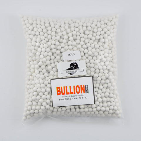 Image of small, 6mm zirconia tumbling media, resembling tiny, smooth, shiny spheres with a metallic sheen. They are neatly packed in BullionCare packaging, which is a sturdy, clear plastic container with a secure lid. 